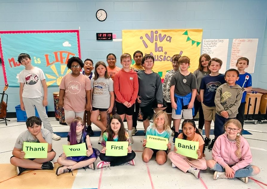 Sycamore Elementary children gather and hold signs for a picture